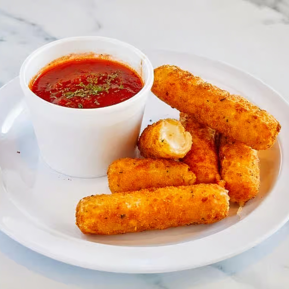 Golden-brown mozzarella sticks with a side of marinara sauce, garnished with herbs, on a white plate.